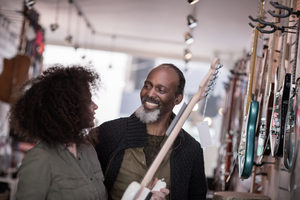 Small business owner helping customer in a guitar store