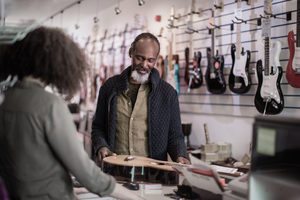 Senior male buying an acoustic guitar