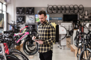 Small business owner using digital tablet in a cycle store