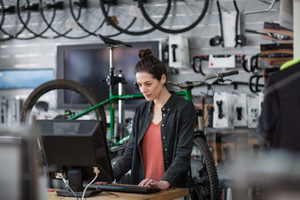 Small business owner using computer in a store