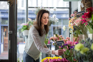 Florist pricing flowers in her store