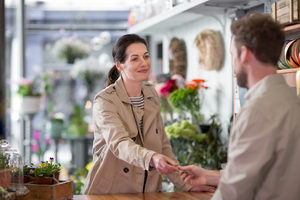 Adult female paying with credit card in a florist