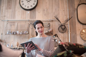 Small business owner using digital tablet in a store
