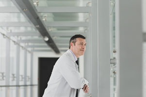 Healthcare professional looking out of window in a modern hospital