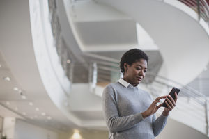 African American using smartphone in modern office