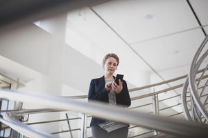 Businesswoman using smartphone in modern office
