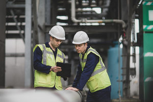 Industrial workers using a digital tablet on site