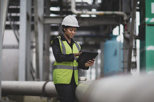 Female industrial worker checking pipeline