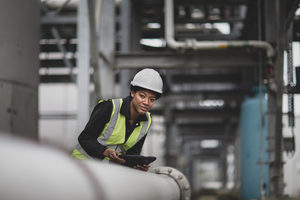 Female industrial worker checking pipeline