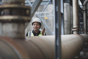Female industrial worker using radio on site