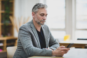Businessman using smartphone at desk