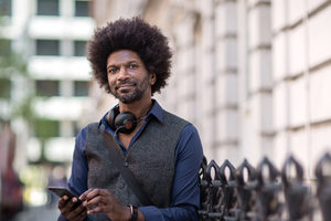 Portrait of African American male outdoors with smartphone