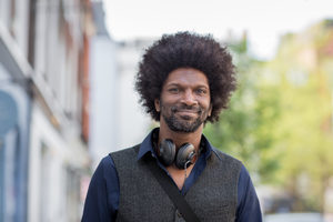 Portrait of happy African American male outdoors in city