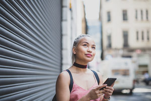 Young adult female using smartphone on street