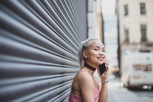 Young adult female on smartphone waiting for a friend