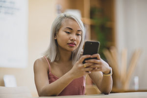 Young adult female using smartphone in college