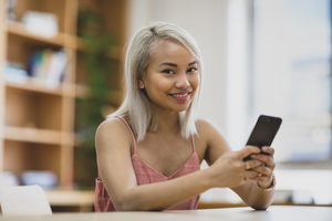 Young adult female using smartphone in college