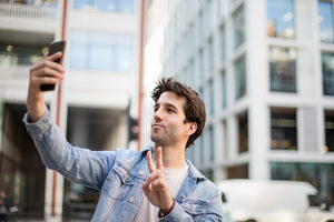 Young adult male tourist posing for selfie
