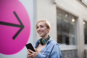 Young adult female using smartphone on street