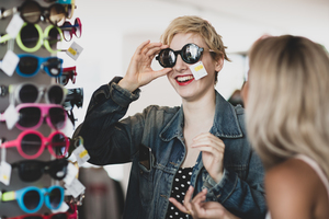 Millennials trying on sunglasses in a vintage store