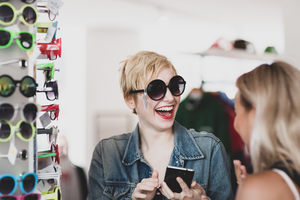 Millennials trying on sunglasses in a vintage store