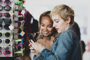 Millennials looking at smartphone in a vintage store