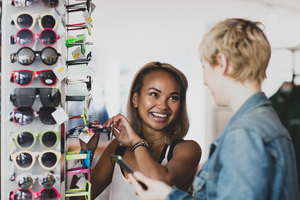 Millennials trying on sunglasses in a vintage store