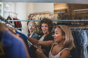 Millennial female friends shopping in a vintage clothing store