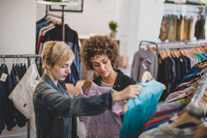 Millennial female friends shopping in a vintage clothing store