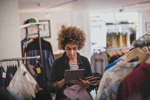 Store manager using digital tablet in a clothing store