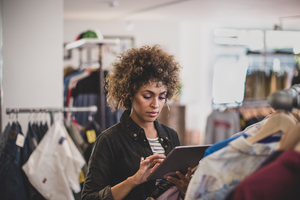 Store manager using digital tablet in a clothing store