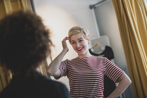 Young adult female trying on clothes in a vintage store