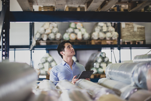 Male working in distribution warehouse with digital tablet