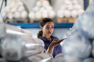 Female scanning item in distribution warehouse