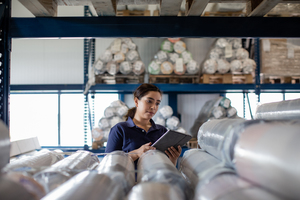 Female working in distribution warehouse with digital tablet