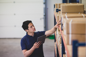 Male working in distribution warehouse with digital tablet