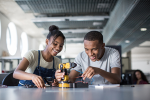 High school students working on a robotic arm in class