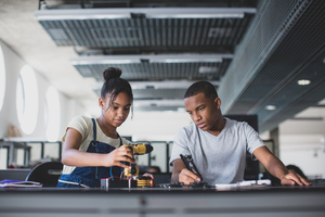 High school students working on a robotic arm in class