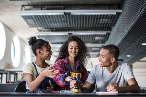 High school students working on a robotic arm in class