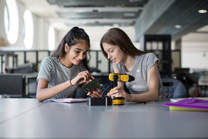 High school students working on a robotic arm in class