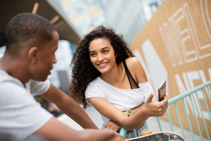 Teenagers socialising outdoors in city with smartphone