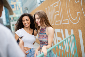 Teenagers socialising outdoors in city with smartphone