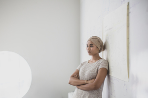 Muslim teacher leaning against whiteboard in a classroom