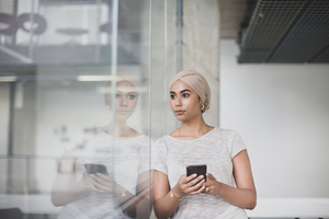 Muslim businesswoman using a smartphone in an office