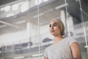 Muslim businesswoman looking out of office window dreaming
