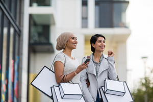 Muslim friends using a smartphone on a shopping trip
