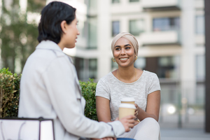 Female Muslim friends having coffee together outdoors