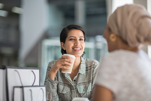 Female Muslim friends having coffee together in a shopping mall