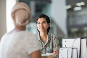 Female Muslim friends having coffee together in a shopping mall