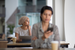 Muslim businesswoman looking out of the window of a cafe